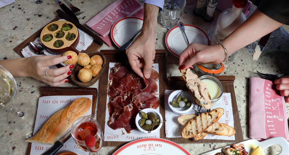 A shared French spread at Bistro des Arts, charcuterie, escargots, baguette and gougères